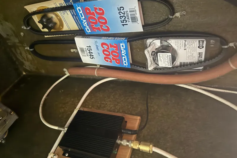 Slide: The Image of Belts and components inside Abbott 36, 1986 model, featuring Dayco Top Cog and Jabsco parts. - 42