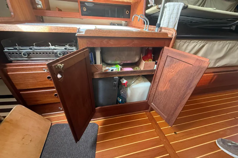 Slide: The Image of Wooden boat kitchen with open cabinets, stove, and sink, Abbott 36, 1986 model. - 45