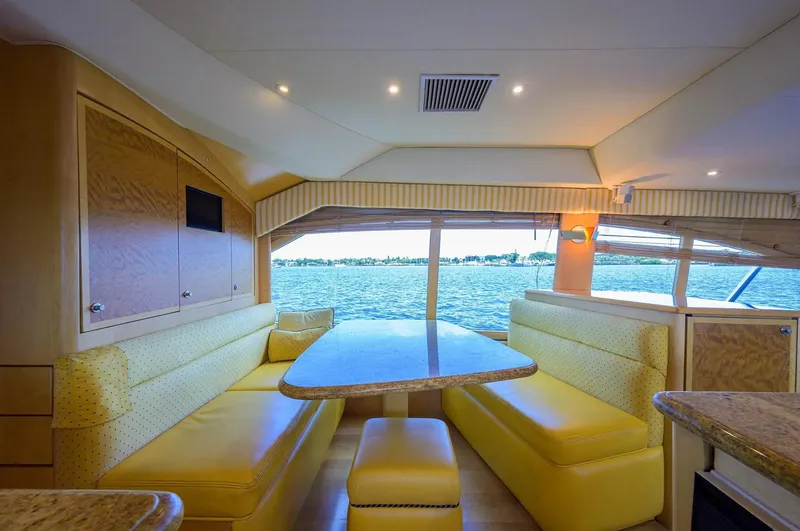 Slide: The Image of Interior of 2003 Ocean Yachts 62 Enclosed Bridge Super Sport with yellow seating and ocean view. - 18