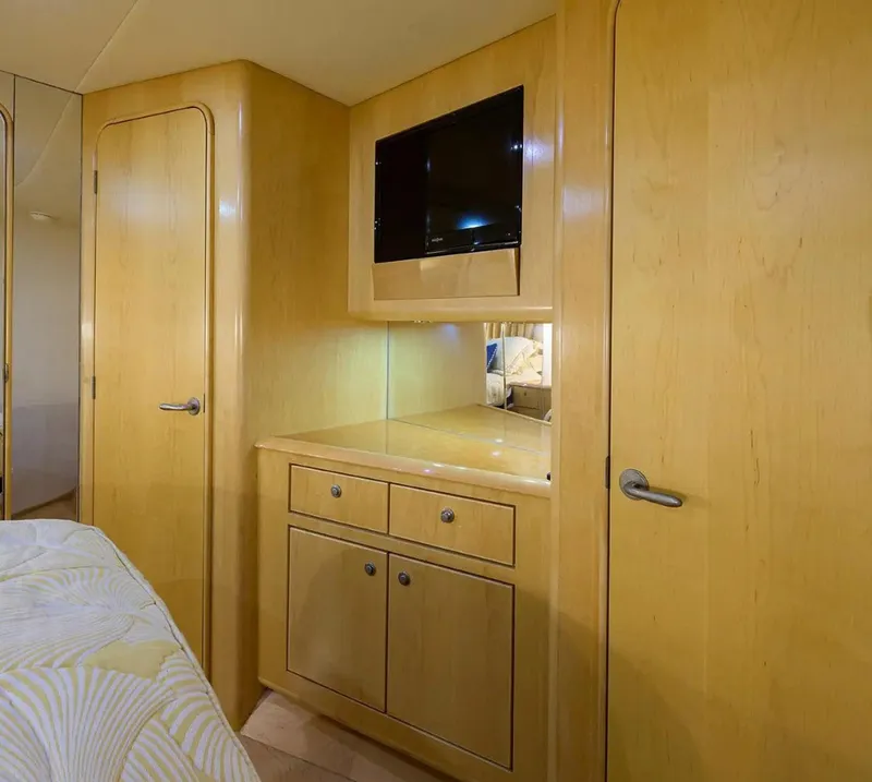 Slide: The Image of Interior of 2003 Ocean Yachts 62 Enclosed Bridge Super Sport, featuring wood cabinetry and TV. - 27