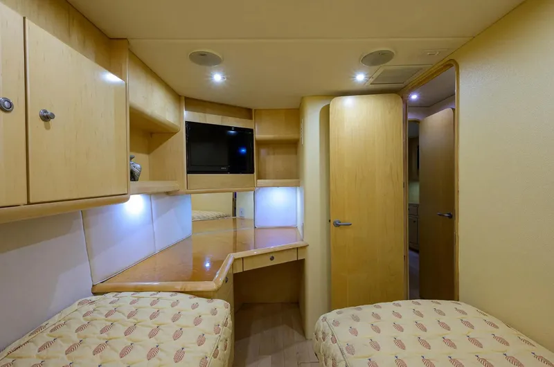 Slide: The Image of Interior of 2003 Ocean Yachts 62 Enclosed Bridge Super Sport, featuring twin beds and wooden cabinetry. - 33