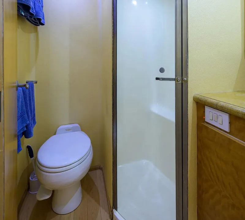 Slide: The Image of Bathroom interior of 2003 Ocean Yachts 62 Enclosed Bridge Super Sport, featuring shower and toilet. - 35