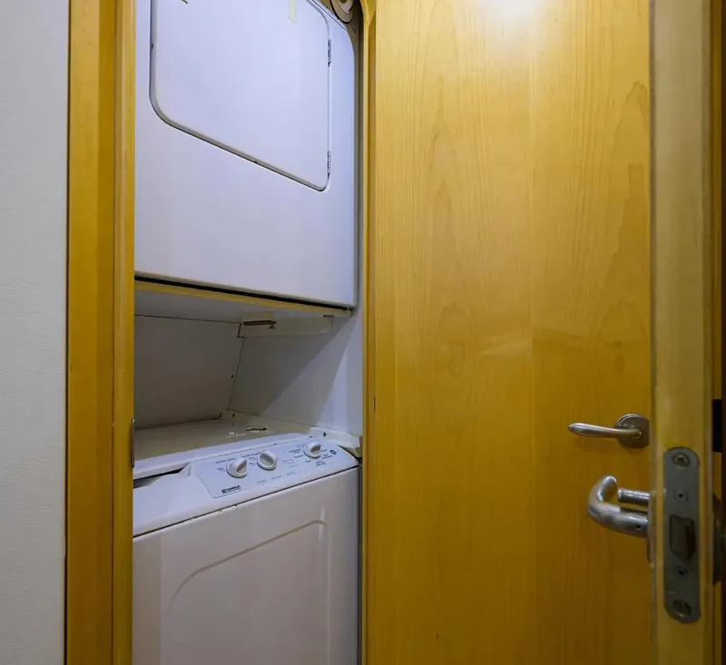 Slide: The Image of Laundry area with stacked washer and dryer in 2003 Ocean Yachts 62 Enclosed Bridge Super Sport. - 36