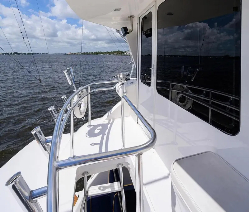 Slide: The Image of 2003 Ocean Yachts 62 Enclosed Bridge Super Sport on open water, featuring sleek design and railing. - 46