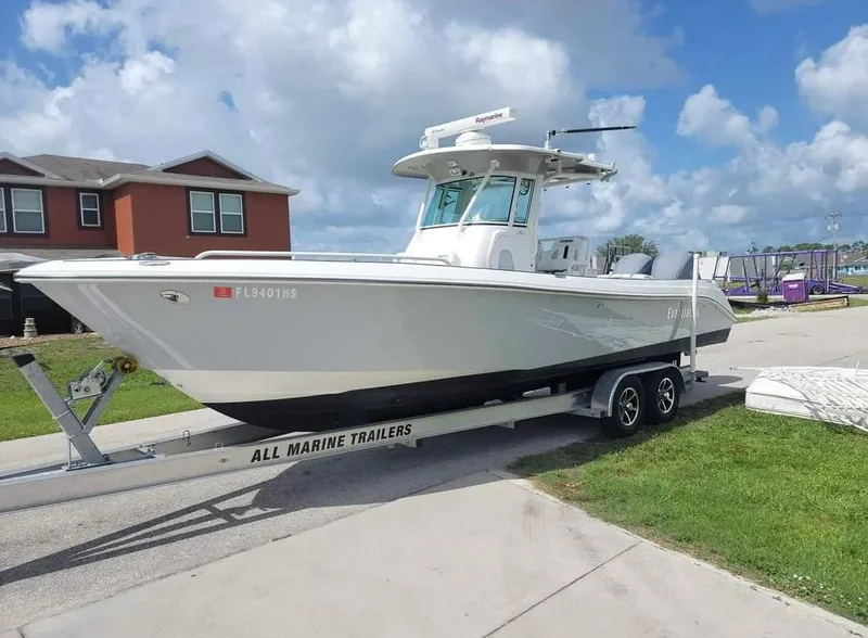 Slide: The Image of 2008 Everglades 290 CC boat on trailer, parked outdoors under a cloudy sky. - 1