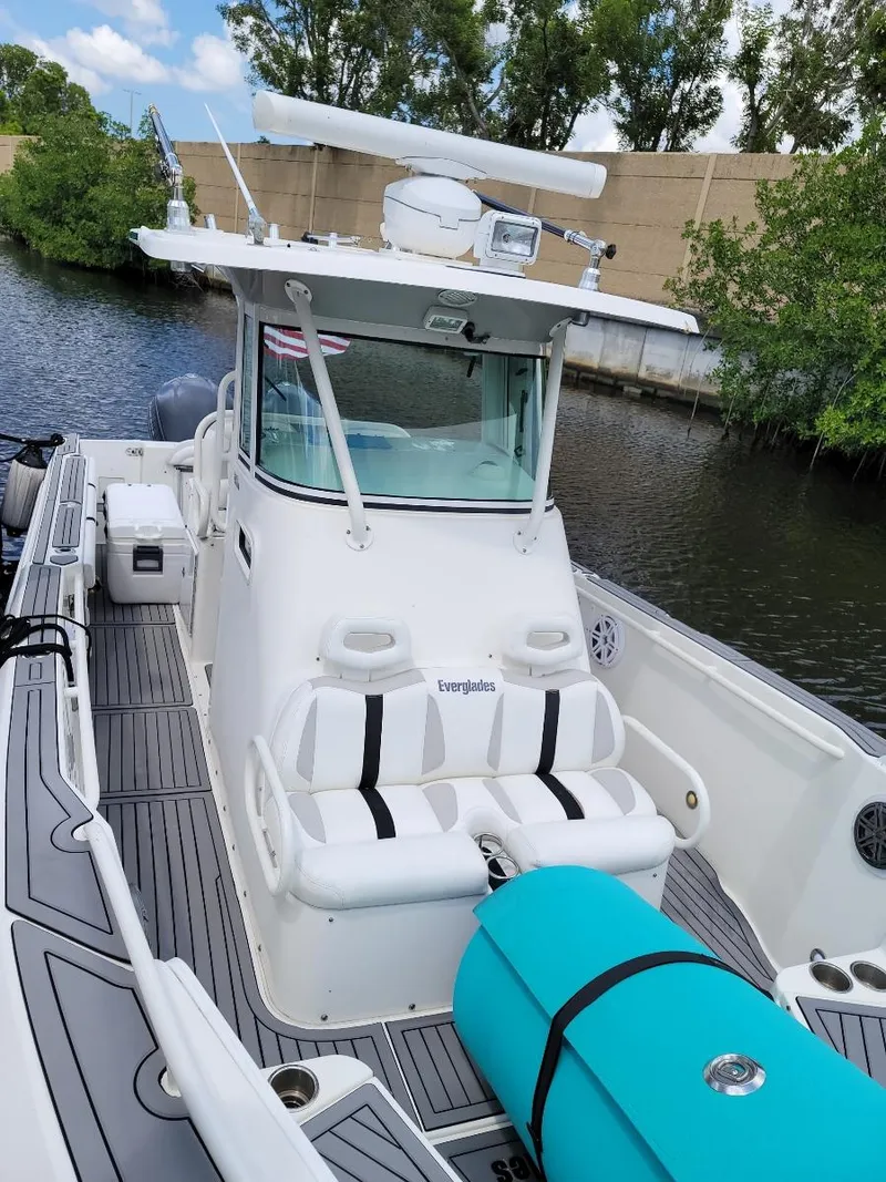 Slide: The Image of 2008 Everglades 290 CC boat docked on a calm waterway, featuring a sleek design. - 2