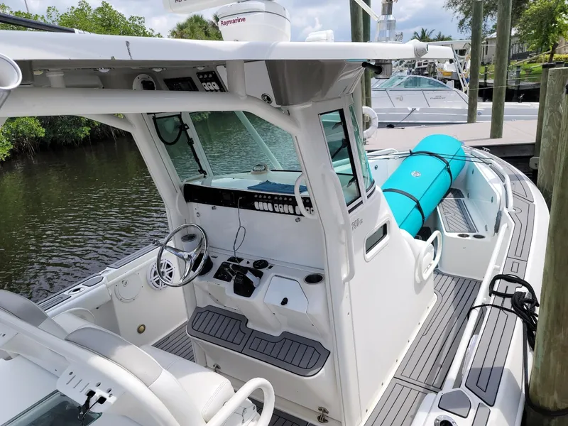 Slide: The Image of 2008 Everglades 290 CC boat docked, featuring a spacious cockpit and modern controls. - 6
