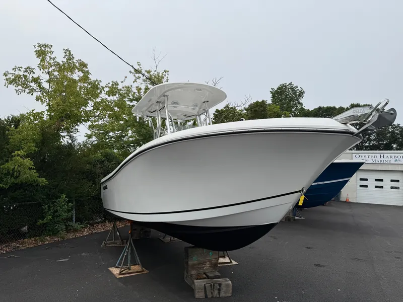 Slide: The Image of 2020 Release 240 R boat on display at a marina, surrounded by trees. - 1