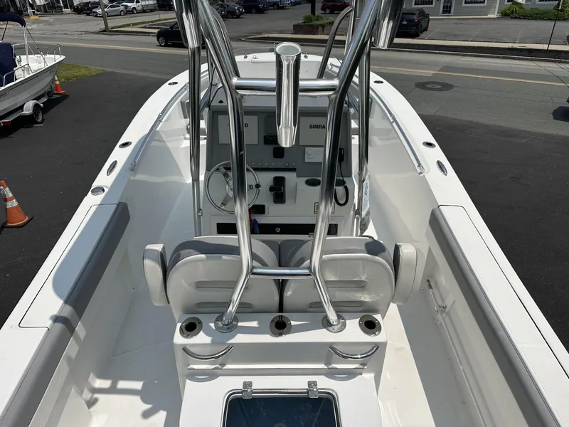 Slide: The Image of 2020 Release 240 R boat interior with steering console and seating, docked on a sunny day. - 15