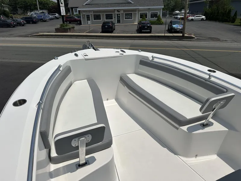 Slide: The Image of Bow seating area of a 2020 Release 240 R boat, parked near a building. - 16
