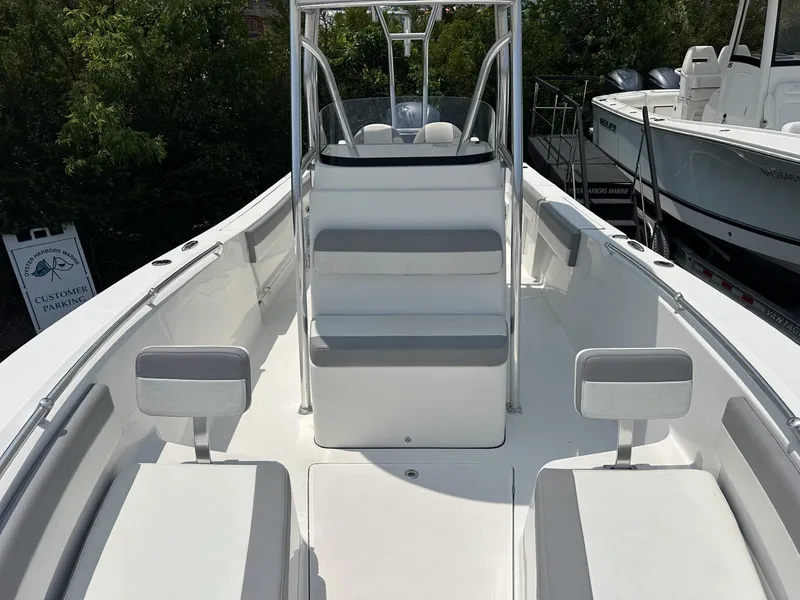 Slide: The Image of 2020 Release 240 R boat interior with seating and console, docked outdoors. - 17