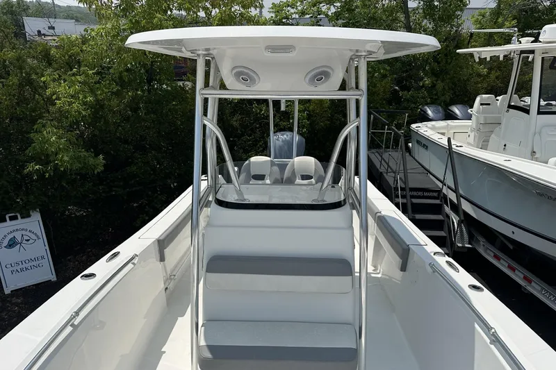 Slide: The Image of 2020 Release 240 R boat with T-top and seating, docked outdoors. - 18