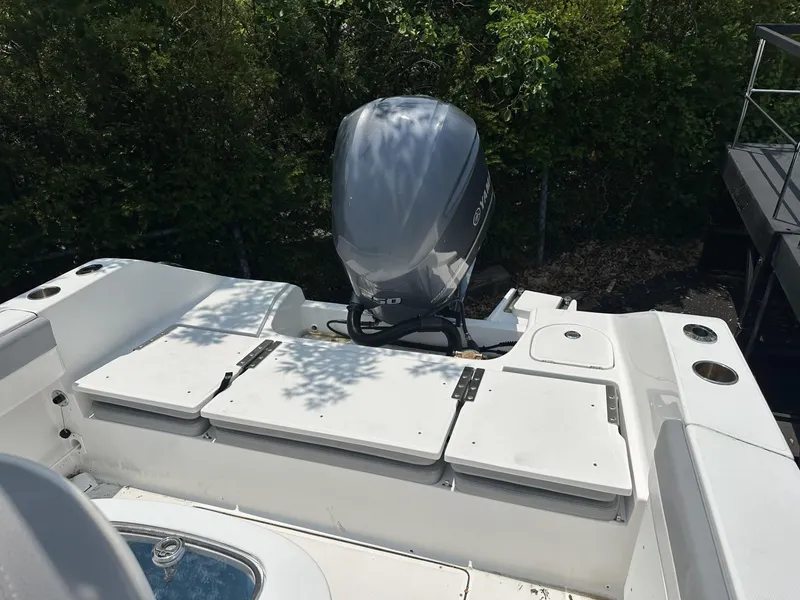 Slide: The Image of 2020 Release 240 R boat with outboard motor, white seating, and lush greenery background. - 7