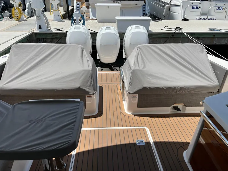 Slide: The Image of 2020 Tiara Sport 38 LX boat with covered seating and triple engines at dock. - 26