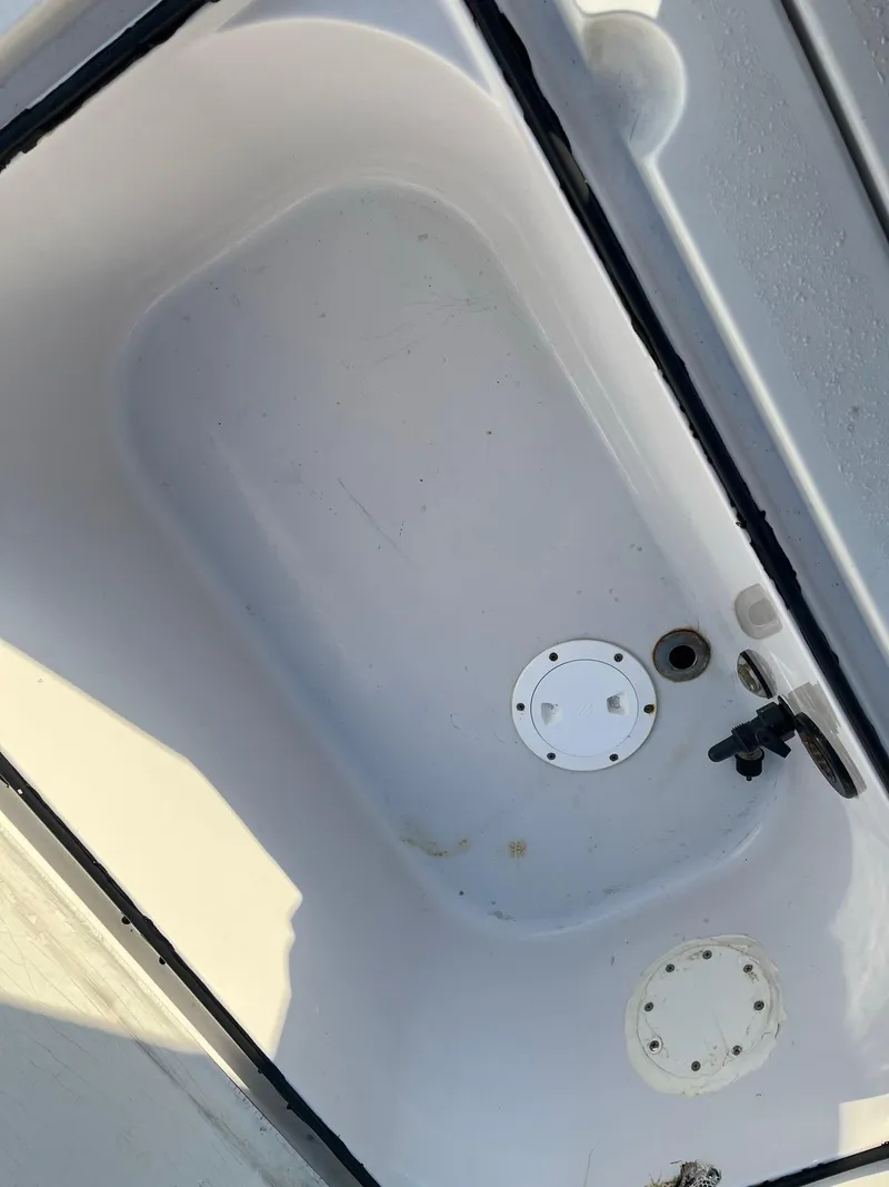 Slide: The Image of 2002 Back Country 201 Pro Guide boat interior compartment, white with visible fittings. - 13