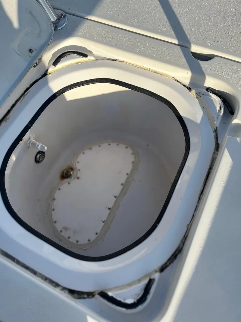 Slide: The Image of 2002 Back Country 201 Pro Guide boat storage compartment, open lid, white interior. - 4