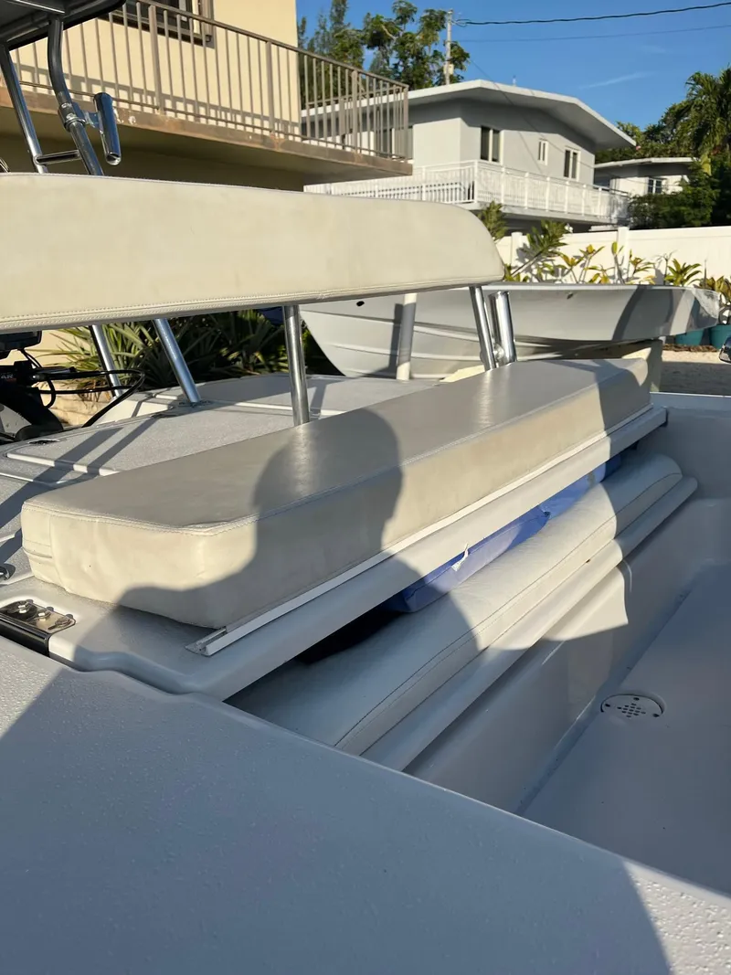 Slide: The Image of 2002 Back Country 201 Pro Guide boat with cushioned seating, docked in a sunny residential area. - 5