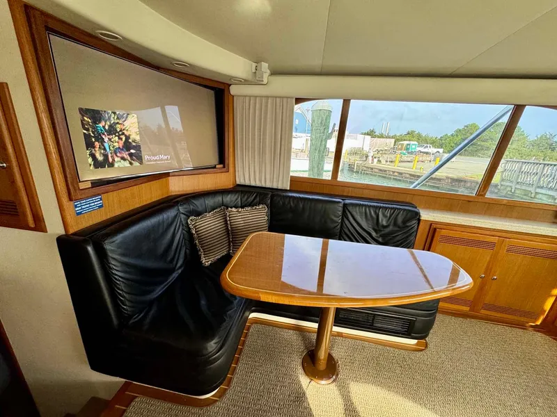 Slide: The Image of Interior of 2002 Cabo 47 Flybridge Sportfisher with leather seating and wooden table. - 10
