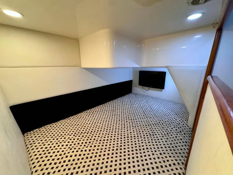 Slide: The Image of Interior cabin of 2002 Cabo 47 Flybridge Sportfisher with patterned flooring and wall-mounted TV. - 18