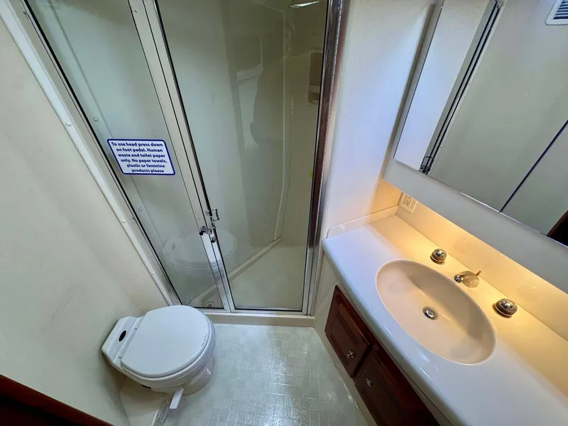 Slide: The Image of Bathroom interior of 2002 Cabo 47 Flybridge Sportfisher with shower, sink, and toilet. - 23