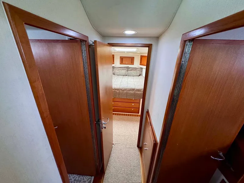 Slide: The Image of Interior hallway of 2002 Cabo 47 Flybridge Sportfisher, leading to a cozy bedroom. - 25