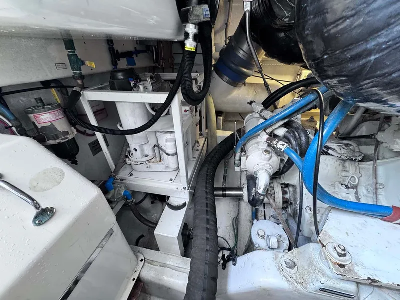 Slide: The Image of Engine room of 2002 Cabo 47 Flybridge Sportfisher with visible machinery and hoses. - 26