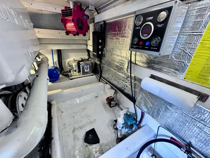 Slide: The Image of Engine room of 2002 Cabo 47 Flybridge Sportfisher with control panel and equipment. - 27