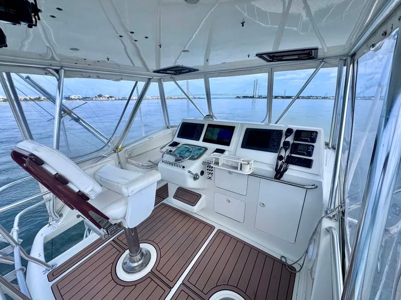 Slide: The Image of 2002 Cabo 47 Flybridge Sportfisher helm with modern controls and ocean view. - 29