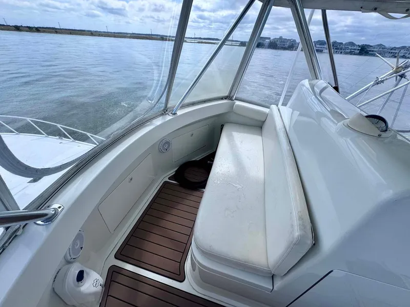 Slide: The Image of 2002 Cabo 47 Flybridge Sportfisher interior with cushioned seating and wooden flooring. - 31