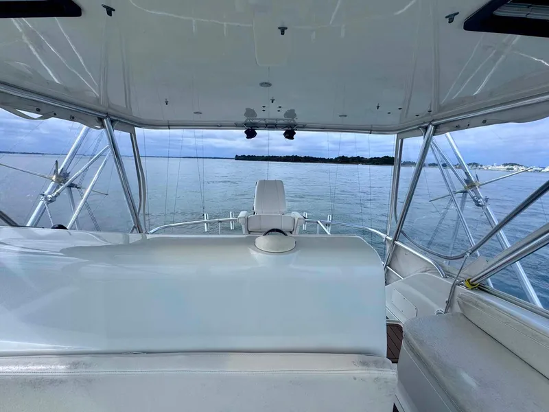 Slide: The Image of 2002 Cabo 47 Flybridge Sportfisher interior with ocean view, featuring helm and seating area. - 32