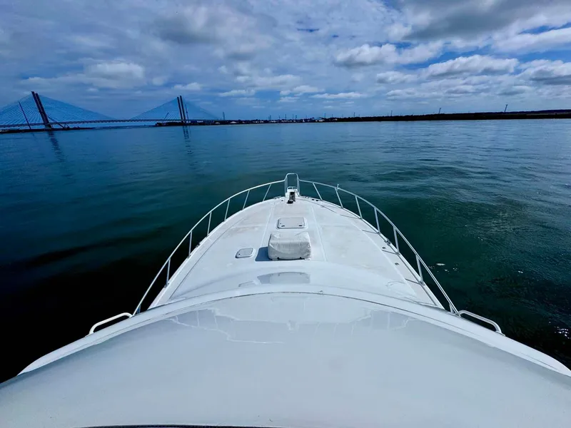 Slide: The Image of 2002 Cabo 47 Flybridge Sportfisher on calm water with bridge in background. - 33