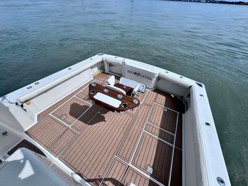 Slide: The Image of 2002 Cabo 47 Flybridge Sportfisher deck with wooden flooring and fishing chair. - 35