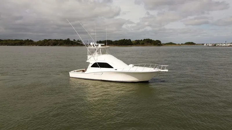 Slide: The Image of 2002 Cabo 47 Flybridge Sportfisher on calm water under cloudy sky. - 4