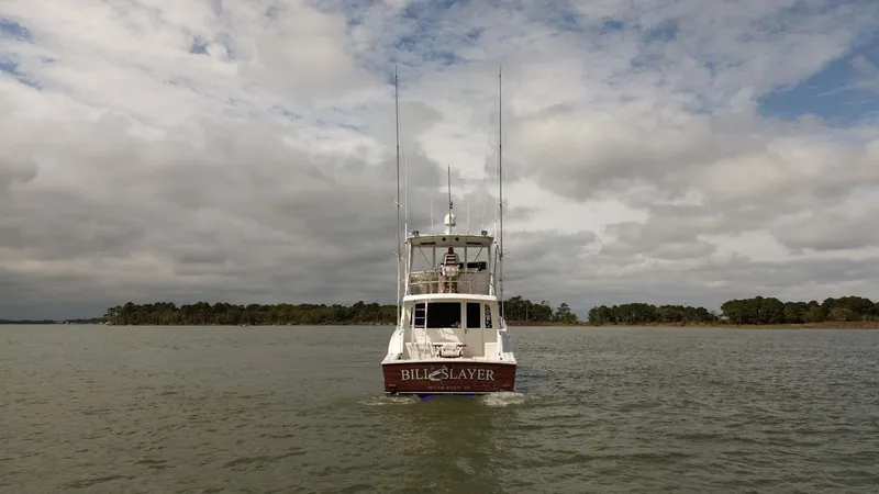 Slide: The Image of 2002 Cabo 47 Flybridge Sportfisher on calm water under cloudy sky. - 6