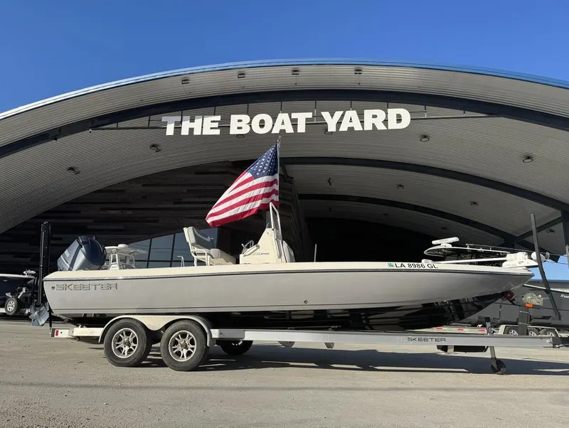 Slide: The Image of 2019 Skeeter SX 240 boat on trailer at The Boat Yard, with American flag. - 19