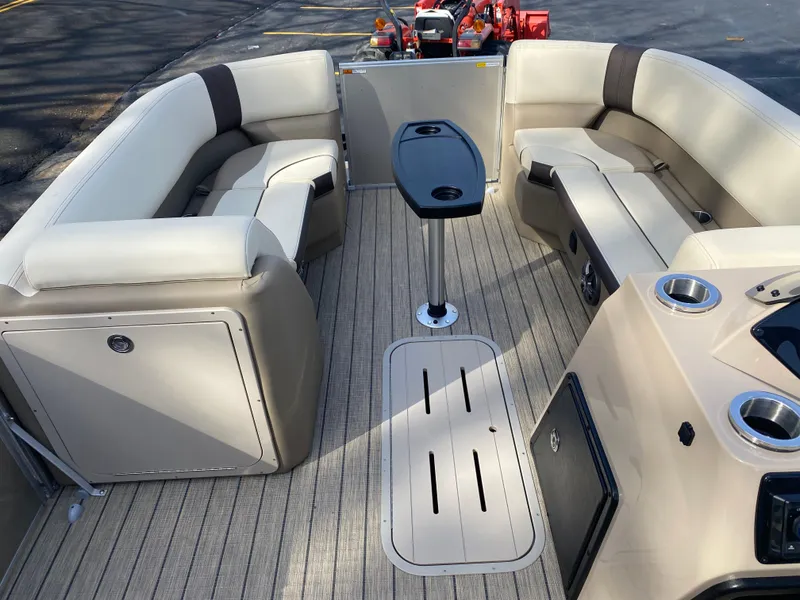 Slide: The Image of 2025 SunCatcher Select 322SS boat interior with beige seating and central table. - 14