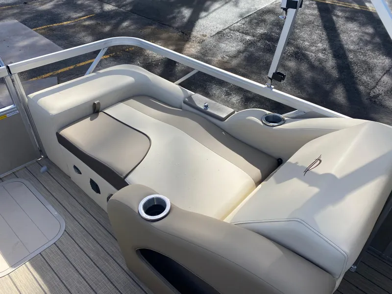 Slide: The Image of 2025 SunCatcher Select 322SS boat interior with beige seating and cup holders. - 16