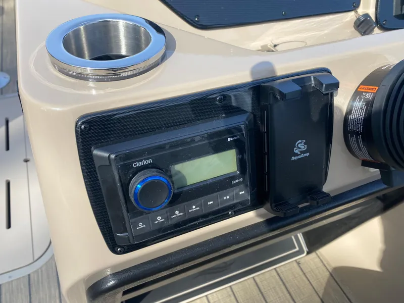Slide: The Image of Control panel of 2025 SunCatcher Select 322SS boat with audio system and cup holder. - 19