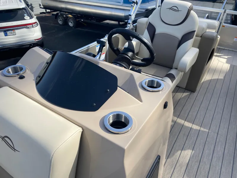 Slide: The Image of 2025 SunCatcher Select 322SS boat interior with steering wheel and cup holders. - 23