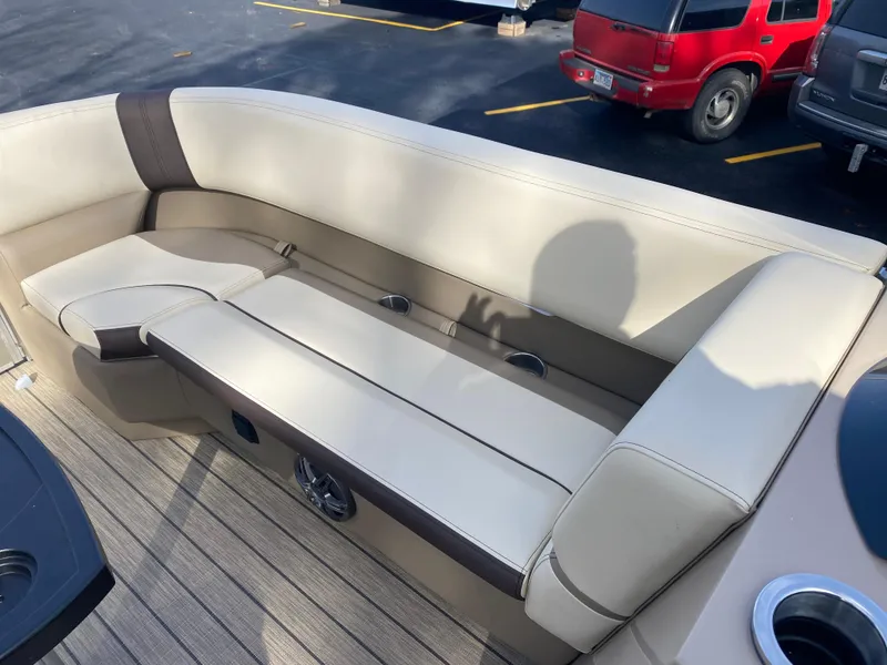 Slide: The Image of 2025 SunCatcher Select 322SS boat interior with beige seating and cup holders. - 26