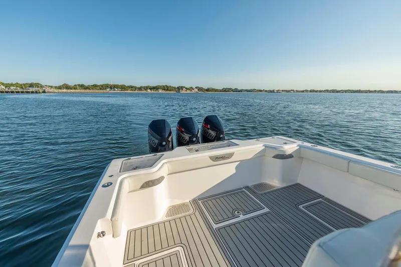 Slide: The Image of 2021 Front Runner 36 Center Console boat on calm water, featuring triple outboard engines. - 14