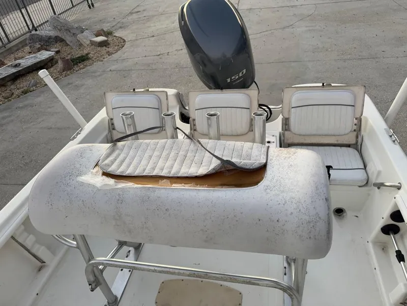 Slide: The Image of 2014 NauticStar 215 XTS Shallow Bay boat interior with worn seating and outboard motor. - 12