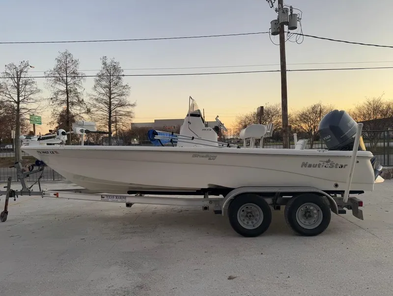 Slide: The Image of 2014 NauticStar 215 XTS Shallow Bay boat on trailer at sunset. - 2