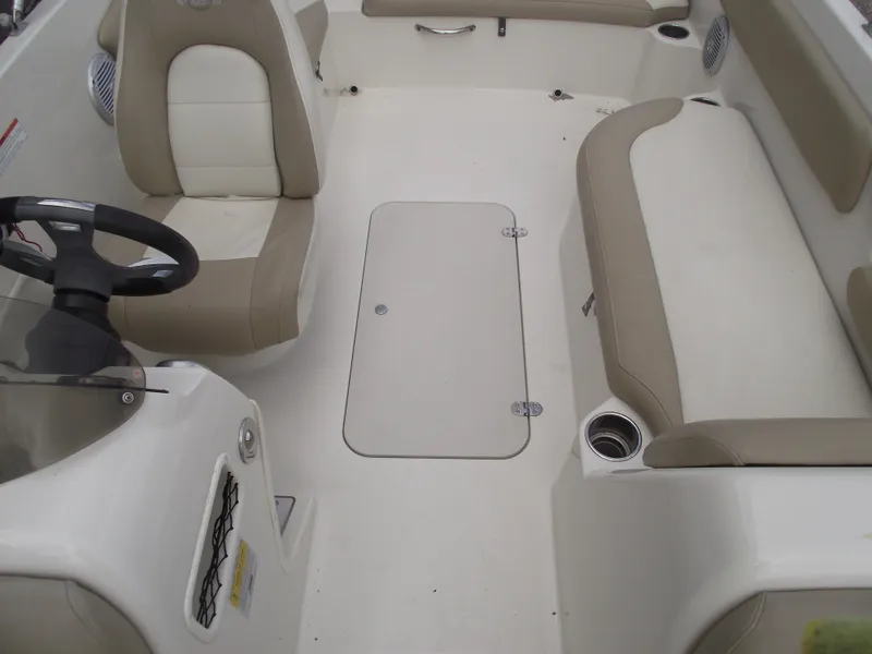 Slide: The Image of 2016 Stingray 182 SC boat interior with beige seating and steering wheel. - 13