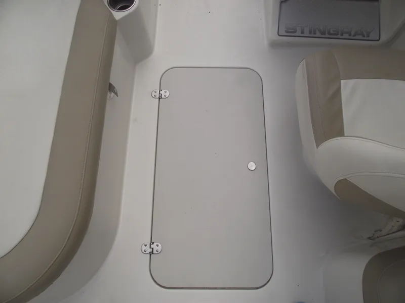 Slide: The Image of 2016 Stingray 182 SC boat interior with beige seating and storage compartment. - 14