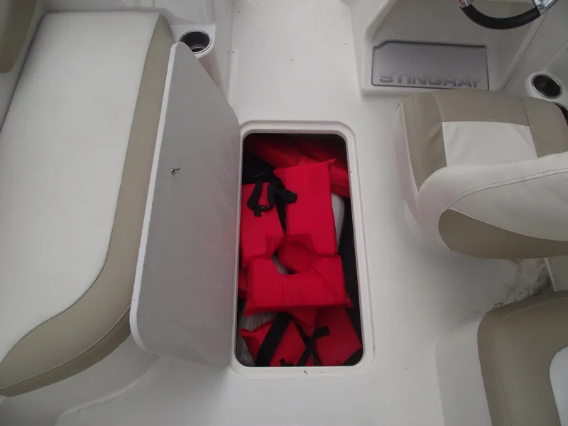 Slide: The Image of Storage compartment with red life jackets on a 2016 Stingray 182 SC boat. - 15