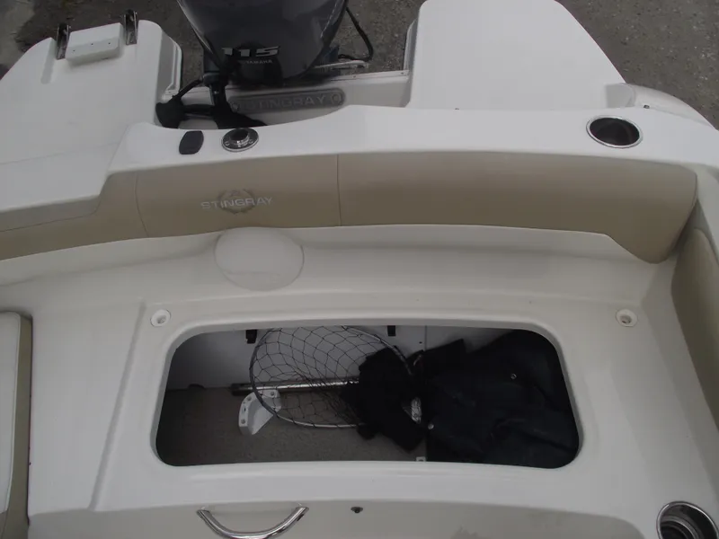 Slide: The Image of 2016 Stingray 182 SC boat interior with storage compartment and fishing net. - 21