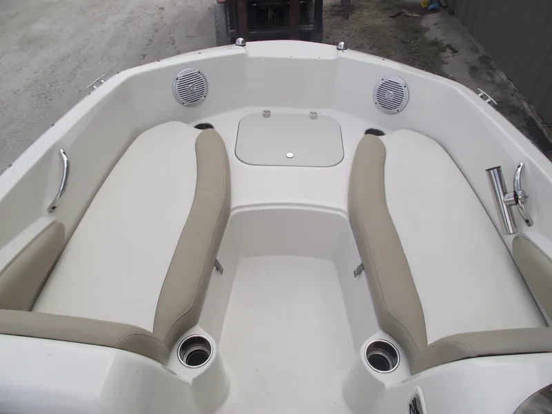 Slide: The Image of 2016 Stingray 182 SC boat interior with beige seating and cup holders. - 6