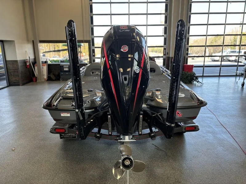 Slide: The Image of 2024 Bass Cat Caracal STS boat, rear view in showroom, showcasing motor and design. - 10