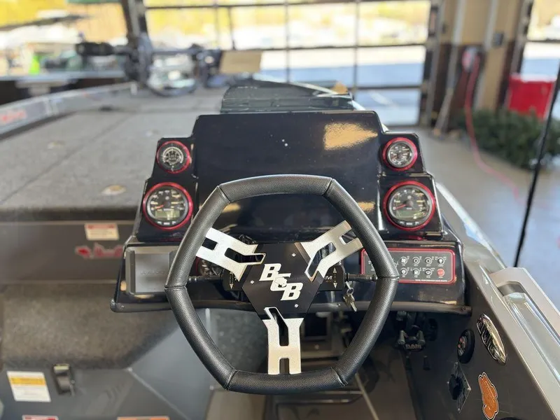 Slide: The Image of 2024 Bass Cat Caracal STS boat dashboard with steering wheel and gauges. - 4